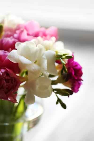 Vackra vårblommor i vas på fönsterkarmen bakgrund — Stockfoto