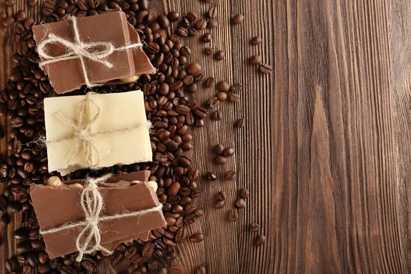 Stack of tied chocolate with coffee beans on wooden table, top view — Stock Photo, Image