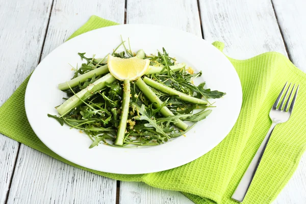 Plade af grøn salat med agurk, arugula og rosmarin på træbaggrund - Stock-foto