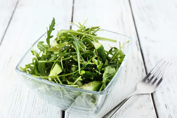 Glasschale mit grünem Salat auf Holzgrund — Stockfoto