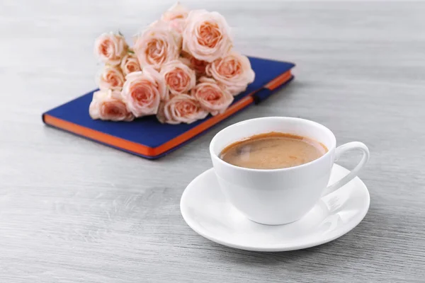 Rosas frescas con diario y taza de café sobre fondo de madera — Foto de Stock