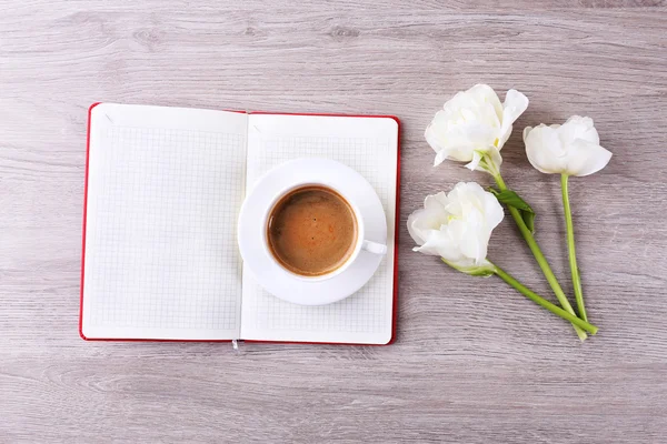 Krásné tulipány s deník a šálek kávy na dřevěný stůl, pohled shora — Stock fotografie