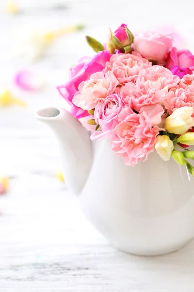 Vackra vårblommor i tekanna på träbord, närbild — Stockfoto