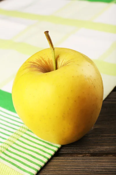 Jablko s ubrouskem na dřevěný stůl, detail — Stock fotografie