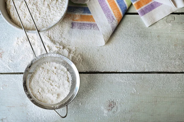 Sifting flour through sieve on wooden table, top view — Stock Photo, Image