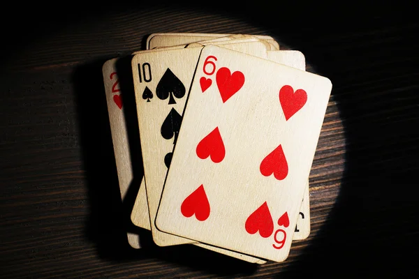 Stos kart do gry w świetle na drewnianym stole, widok z góry — Zdjęcie stockowe