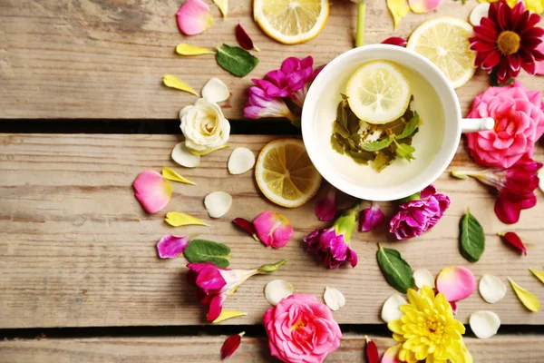 Kopp örtte med vackra blommor, på trä bakgrund — Stockfoto