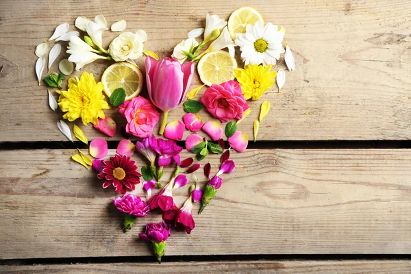 Serca pięknych kwiatów, na drewnianym stole — Zdjęcie stockowe