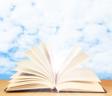 Tablo gökyüzü arka plan üzerinde kitap açıldı