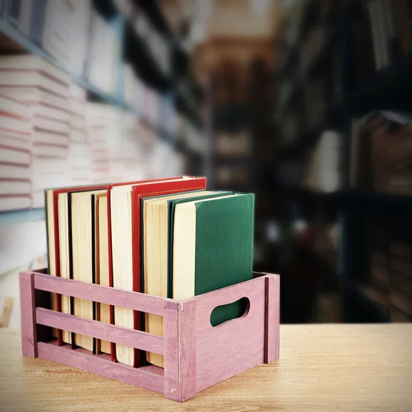 Livres en caisse en bois sur fond de bibliothèque — Photo