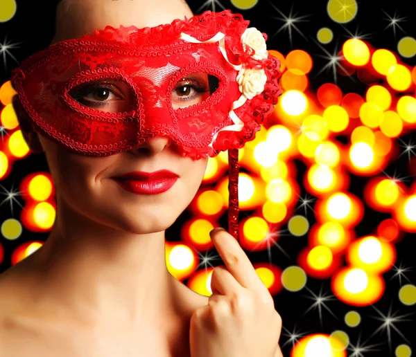 Bella ragazza con maschera mascherata su sfondo luci — Foto Stock