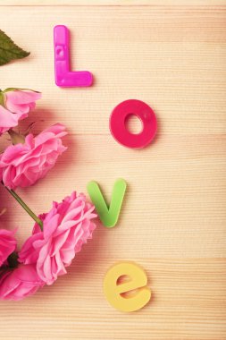 Ahşap arka plan üzerinde kelime aşk ile güzel güller