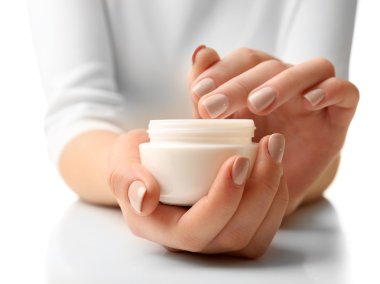 Female hands holding jar of cream isolated on white clipart