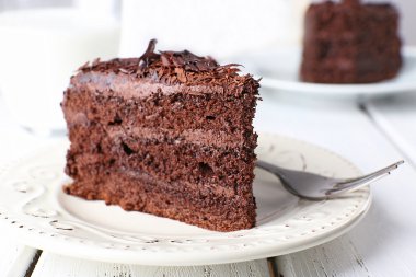 Ahşap masa, closeup tabağa lezzetli çikolatalı pasta dilimlenmiş