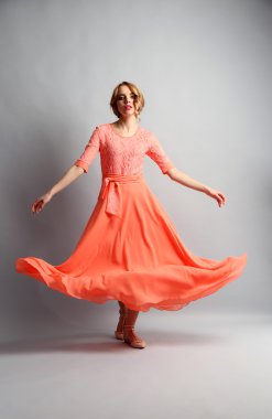 Işık arka plan üzerinde poz renk elbiseli güzel genç kadın