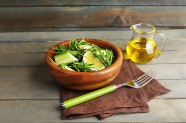 Yeşil salata ve ahşap zemin üzerine dilimlenmiş limon kase