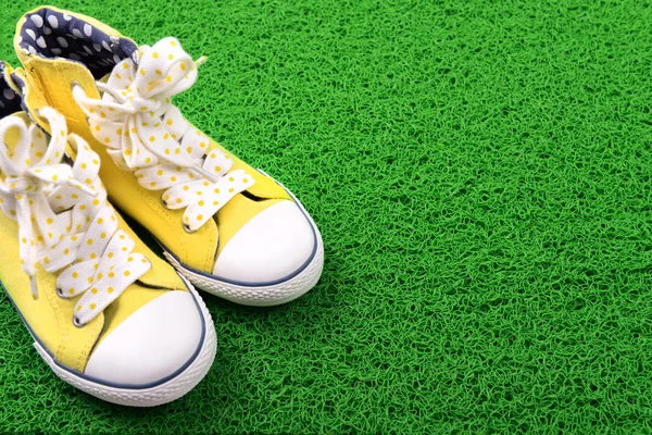 Yeşil Halı zemin üzerine spor ayakkabı — Stok fotoğraf