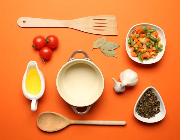 Lebensmittelzutaten und Küchenutensilien zum Kochen auf orangefarbenem Hintergrund — Stockfoto