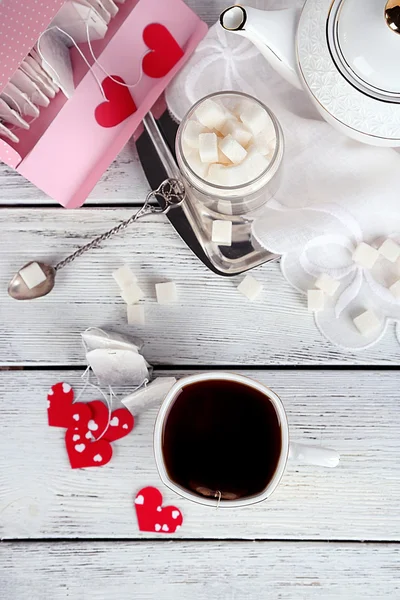 Teabag Etiketler, kutu ve çaydanlık ahşap arka plan üzerinde kalp şeklinde — Stok fotoğraf