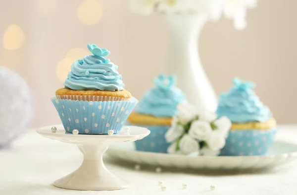 Deliciosos cupcakes en la mesa sobre fondo claro — Foto de Stock