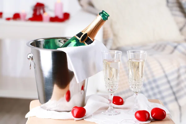 Champagne bottle in bucket,  glasses and rose petals for celebrating Valentines Day — Stock Photo, Image