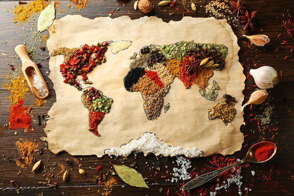 Map of world made from different kinds of spices on wooden background