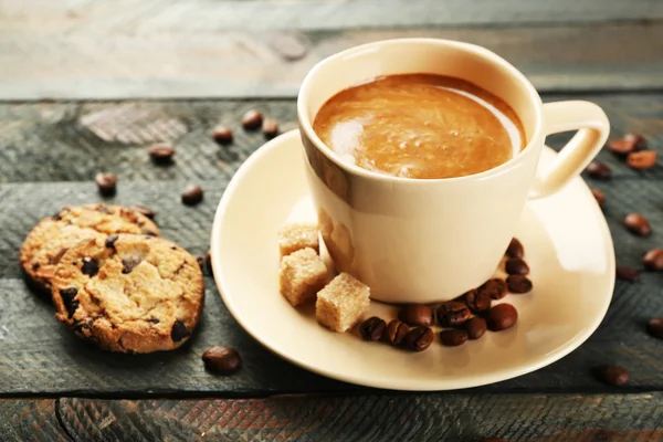 Xícara de café e biscoitos saborosos no fundo de madeira — Fotografia de Stock