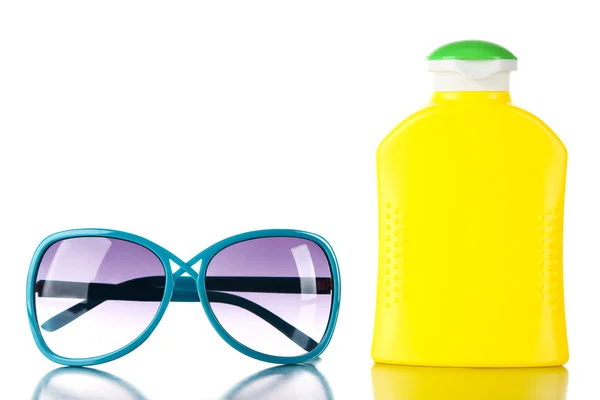 Bottle of suntan cream with sunglasses isolated on white — Stock Photo, Image