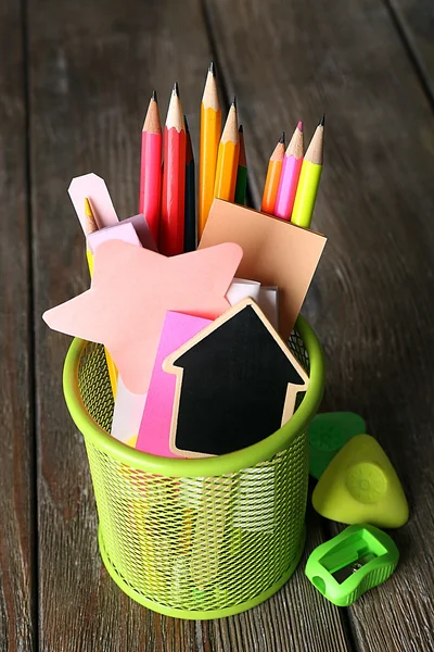 Colorful pencils with paper notes in metal stand on wooden table background — Stock Photo, Image