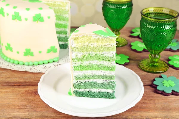 Bodegón con pastel en rodajas y cerveza verde para el Día de San Patricio sobre mesa de madera y fondo borroso —  Fotos de Stock