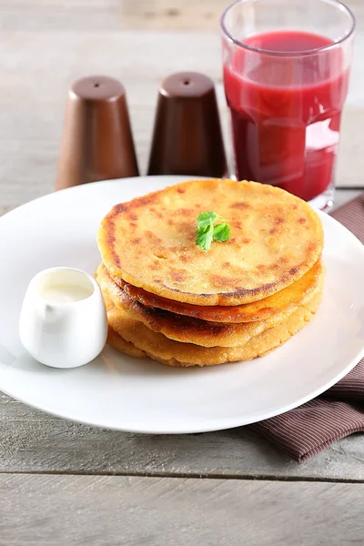 Stack of corn tortillas with stuffing and glass of juice on wooden table background — Stock Photo, Image