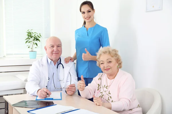 Happy doctors and patients in hospital clinic — Stock Photo, Image
