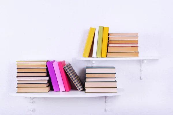 Books on shelves on white wall background — Stock Photo, Image