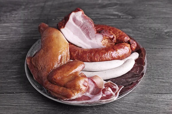 Assortment of deli meats on metal tray on color wooden background — Stock Photo, Image