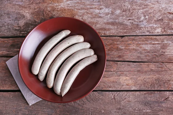 Embutidos cocidos en plato sobre fondo de mesa de madera — Foto de Stock