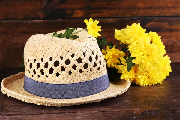 Chapeau avec des fleurs sur fond en bois — Photo