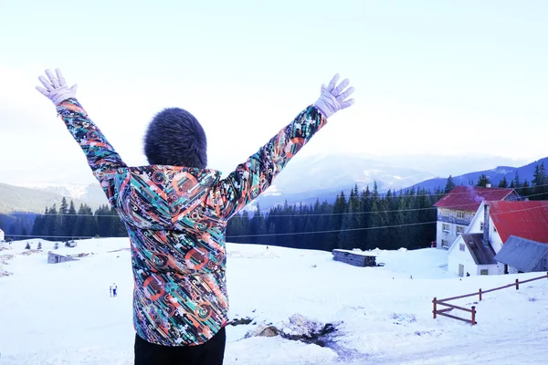 Mulher em roupas quentes virou as costas levantando as mãos sobre as montanhas dos Cárpatos no inverno — Fotografia de Stock