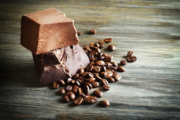 Chocoladerepen met koffiebonen op houten achtergrond — Stockfoto