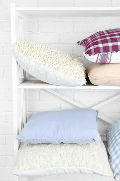 Decorative pillows on shelf on wall background — Stock Photo, Image