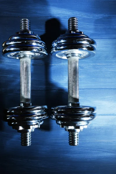 Dumbbells on color wooden background — Stock Photo, Image