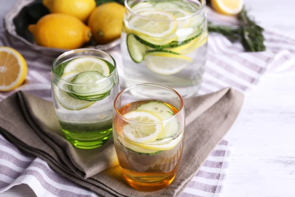 Fresh water with lemon and cucumber in glassware on napkins, closeup — Stock Photo, Image