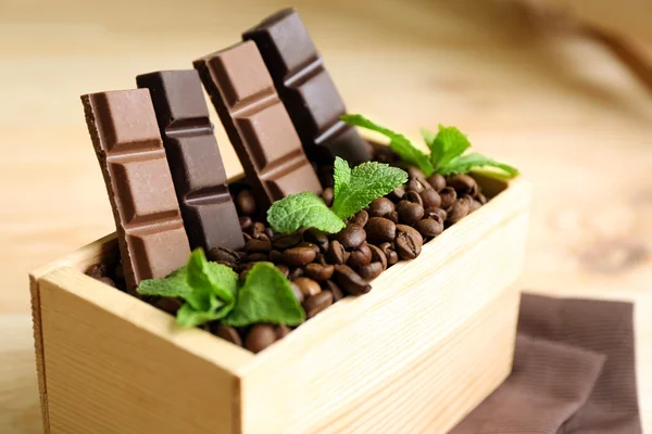 Bodegón con set de chocolate en caja de madera de granos de café sobre fondo de madera — Foto de Stock