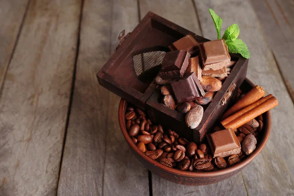 Stillleben mit Schokolade und Kaffeebohnen auf Holzgrund — Stockfoto