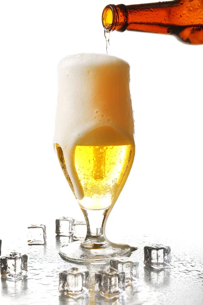 Pouring beer from bottle into glass isolated on white — Stock Photo, Image