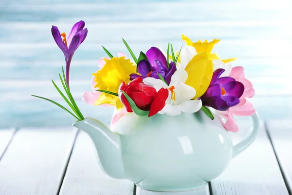 Szép tavaszi virágok a fából készült asztal a kék háttér — Stock Fotó