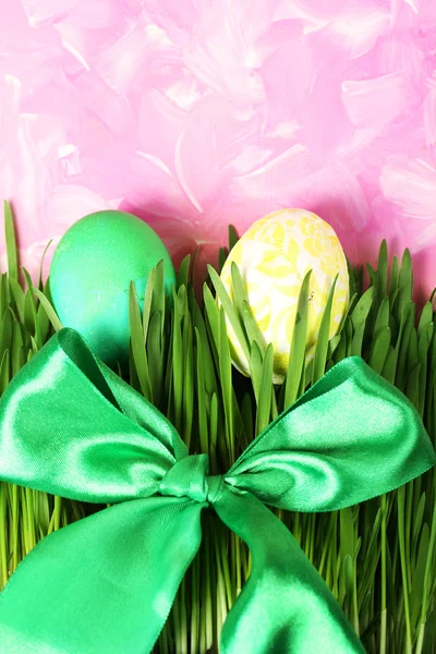 Easter eggs and grass on wooden background — Stock Photo, Image