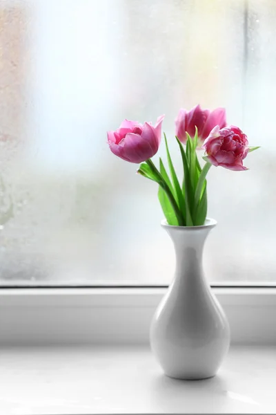 Linda tulipas rosa em vaso no fundo do peitoril da janela — Fotografia de Stock