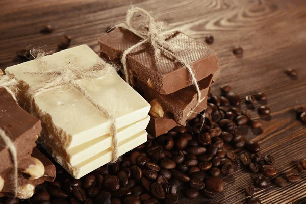Stack of tied chocolate with coffee beans on wooden table, closeup — Stock Photo, Image