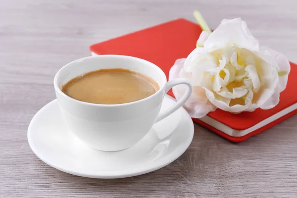 Beautiful tulip with diary and cup of coffee on wooden background — Stock Photo, Image