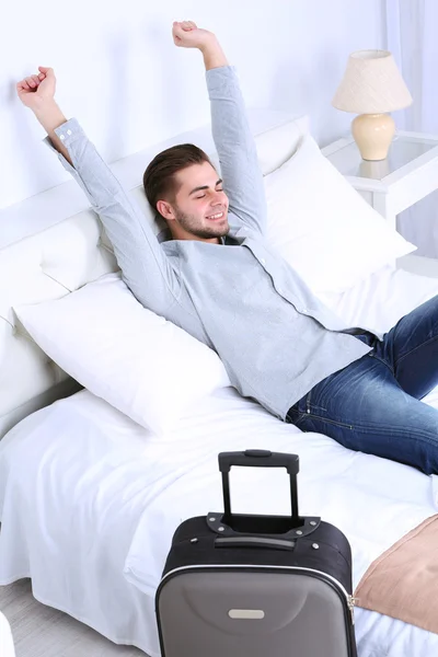 Hombre cansado descansando en la cama en la habitación — Foto de Stock